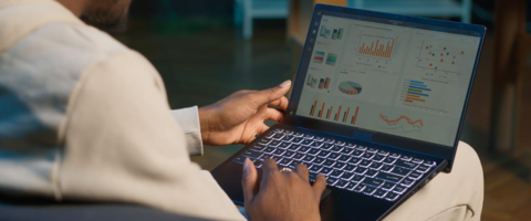 Homem analisando gráficos e dados em um laptop para estratégias de gestão